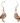 A pair of dangle earrings featuring two burrowing owls made from recycled paperboard. The earrings have a silver-toned hook and bead. The background of the packaging shows a prairie landscape. The packaging also includes the text "Jabebo Studio Inspire Curiosity" and "Burrowing Owl Made with cereal box paperboard."